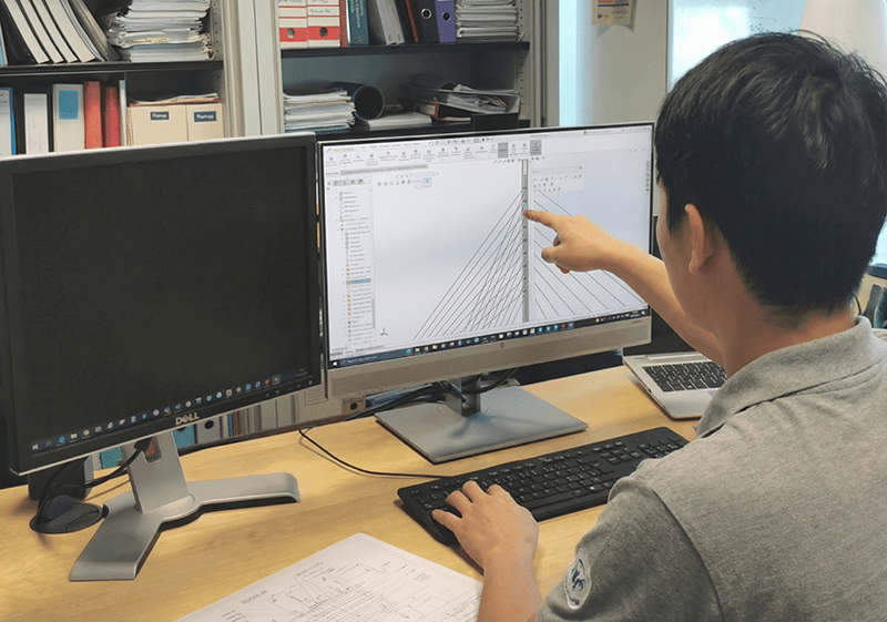 Bridgent design engineers developing cable-stayed bridge solutions using advanced CAD software