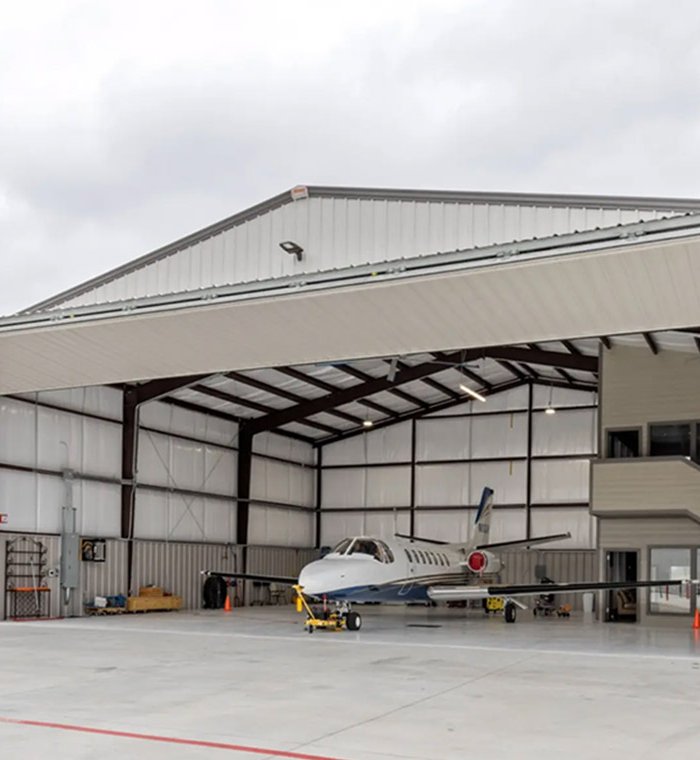Abri pour avion domestique avec structure en acier et panneaux de laine de roche