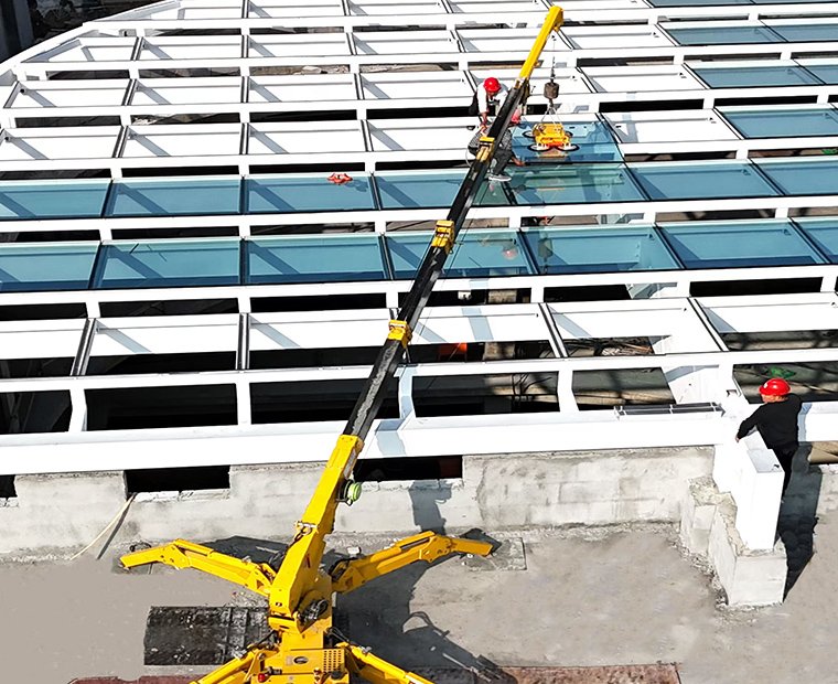 Spider crane performing glass curtain wall installation