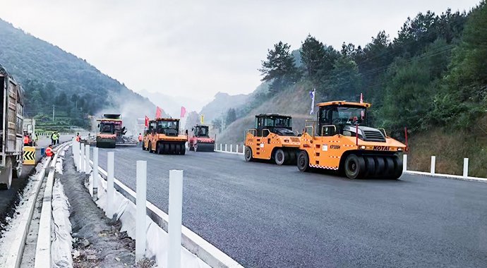 Compactadores de neumáticos de 30 toneladas de KOTAI en operación conjunta para la construcción de pavimento asfáltico en carreteras de montaña.